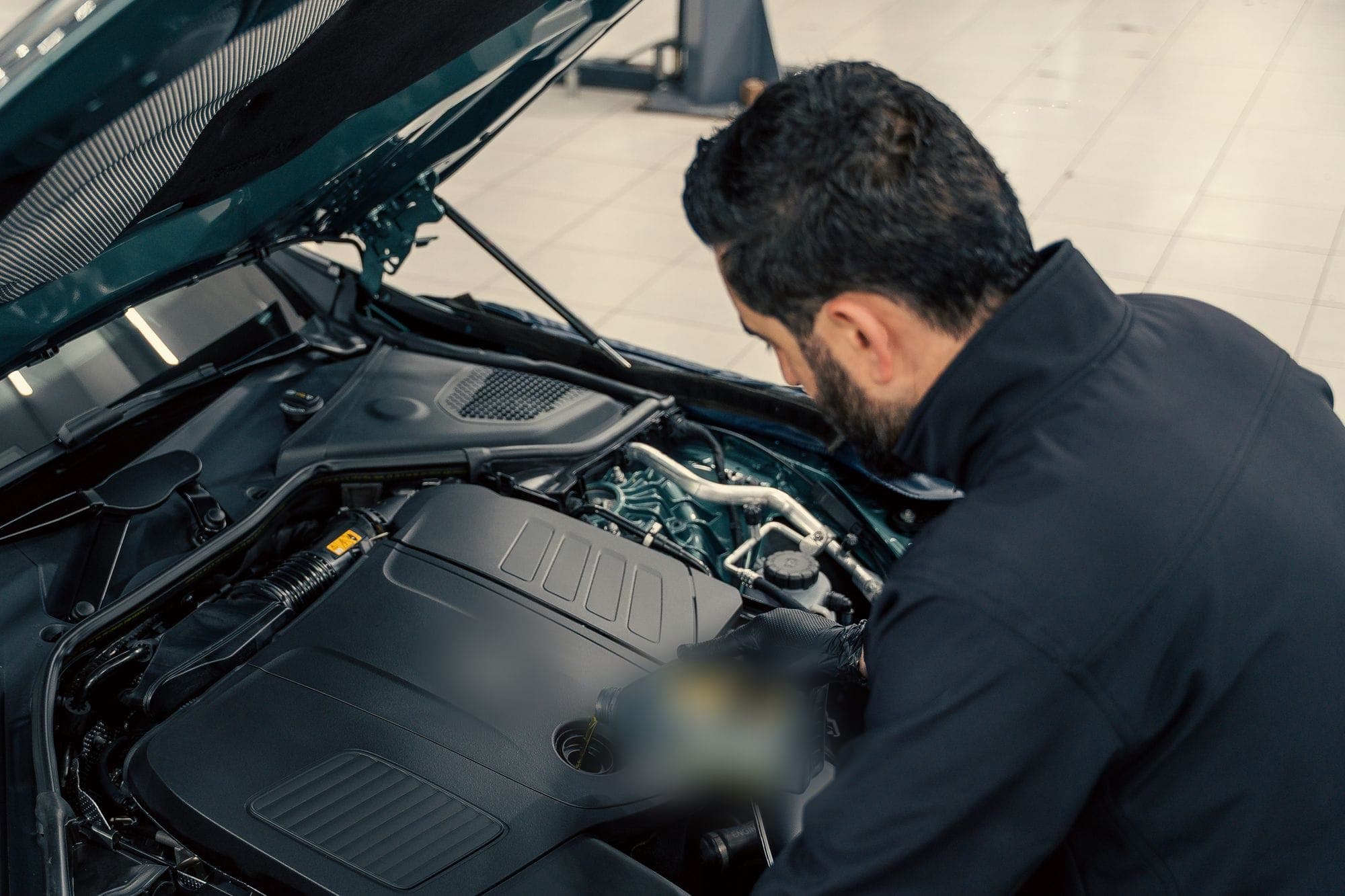 A mechanic leaning over an open engine bay